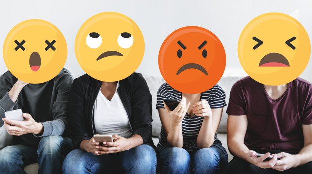 Diverse people with negative emoticons using mobile phones